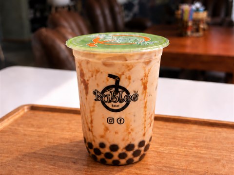 Bublee Brown Sugar Milk Tea in a sealed cup with black tapioca pearls.